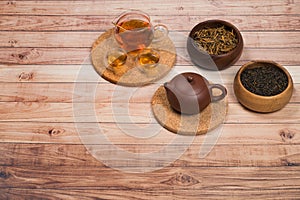 Traditional asian clay teapot with tea set and wooden bowls