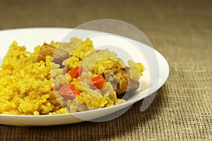 Traditional asian dish - pilaf from rice, vegetables and meat in a white plate.