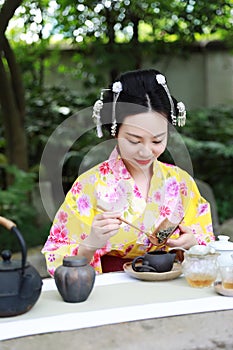 Traditional Asian Japanese beautiful woman show tea art green tea ceremony in outdoor garden