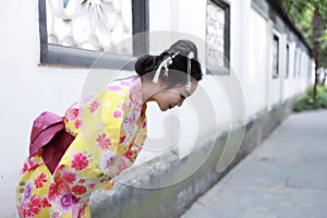 Traditional Asian Japanese beautiful woman wears kimono in a spring garden park bow