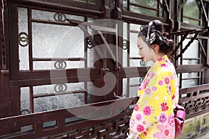 Traditional Asian Japanese woman bride Geisha wearing kimono play in a graden