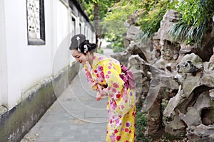 Traditional Asian Japanese woman bride Geisha wearing kimono play in a graden