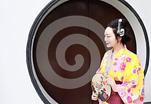 Traditional Asian Japanese woman bride Geisha wearing kimono play in a graden hold a fan