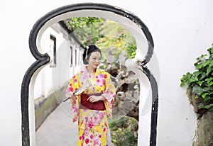 Traditional Asian Japanese woman in a garden hold a fan