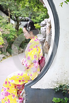 Traditional Asian Japanese woman Geisha wearing kimono play in a graden