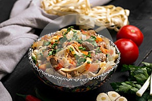 Traditional asian noodle lagman with vegetables and meat photo