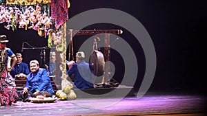 Traditional Asian performance with musicians and a puppet show on a decorated stage