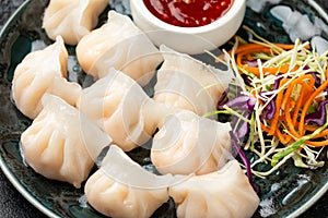 Traditional Asian Prawn or shrimp dumplings hakau, ha kauw or har gow. Served with cabbage, carrot salad and soy and