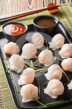 Traditional Asian Prawn or shrimp dumplings hakau, ha kauw or har gow served with sauce. Vertical