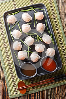 Traditional Asian Prawn or shrimp dumplings hakau, ha kauw or har gow served with sauce. Vertical top view