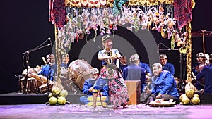 Traditional Asian puppet show with performers in cultural attire and musical instruments on stage