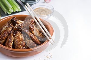 Traditional Asian stir fry chicken wings with sesame and vegetables. Copy space for text