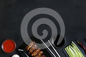 Traditional Asian stir fry wings with sesame. Ingredients and chopsticks on the table