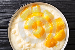 Traditional asian tapioca pudding with coconut milk and fresh mango close-up in a bowl. horizontal top view