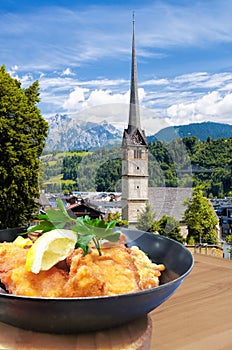 Traditional Austrian gastronomy Schnitzel against Bischofshofen with castle in Austria