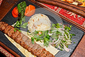 Traditional autyhentic turkish lunch or dinner: kebab with rice and vegetables, spinach and egg pide