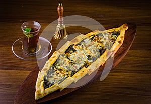 Traditional autyhentic turkish lunch or dinner: kebab with rice and vegetables, spinach and egg pide, pita flat bread and puff hot