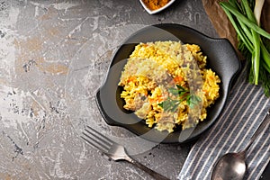 Traditional azian pilaf served in plate on gray background