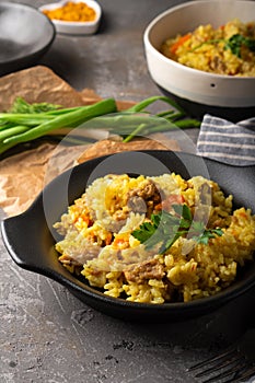 Traditional azian pilaf served in plate on gray background