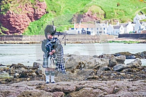 Traditional bagpiper in the scottish highlands