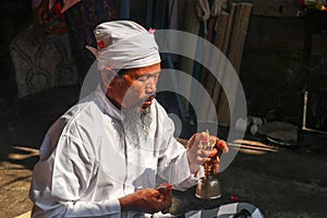 Traditional Balinese blessing ceremony by wedding, Priest conduct the ceremony on the shore. Soft focus