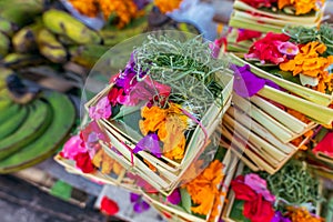 Traditional balinese handmade offering to gods on a morning market in Ubud. Bali island.