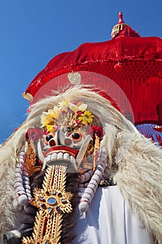 Traditional Balinese spirit Rangda under red umbrella
