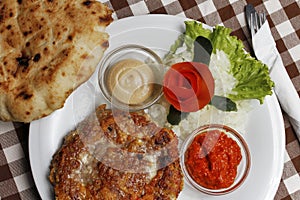 Traditional Balkan pljeskavica with cheese grilled meat with lepinja bread