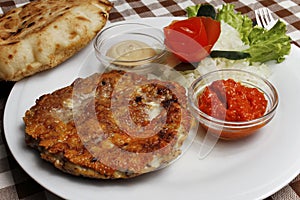 Traditional Balkan pljeskavica with cheese grilled meat with lepinja bread photo