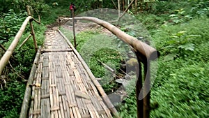 a traditional bamboo bridge in the middle of the forest