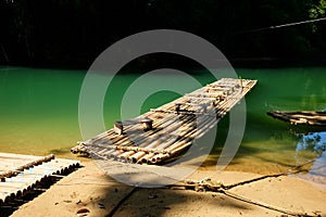 Traditional bamboo raft floats over the clear river in the morning