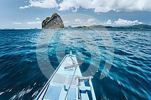 Traditional banca boat arriving amazing Pinagbuyatan Island. A small circular island with huge limestone cliffs and one