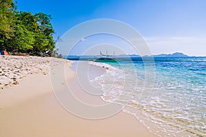 Traditional banca boat in clear water at sandy Beach near El Nido, Philippines