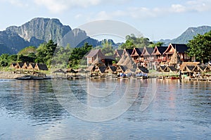 Traditional bangalow with lake front and mountain background photo