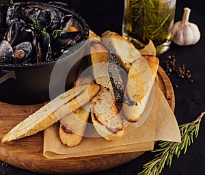 Traditional barbecue italian blue mussel in wine sauce with baguette bread