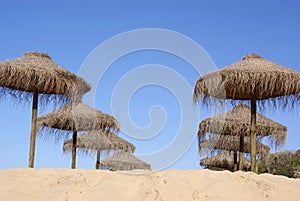 Traditional bast parasols at the sandy Atlantic beach