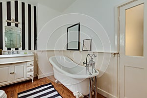 Traditional bathroom with roll top bath and stripy wall