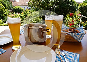 traditional Bavarian meal: white sausages, salty pretzels, sweet mustard, German beer and basket of prezels on Bavarian napkin