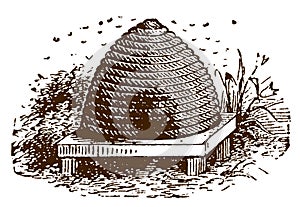 Traditional beehive or skep with swarming bees