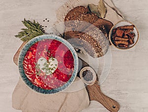 Traditional beet soup borsh with sour cream in a bowl. Rustic style