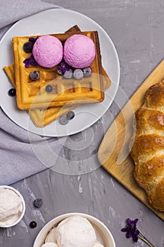 Traditional Belgian waffles top view. Violet flower and blueberry flavor ice cream. Bakery and dessert