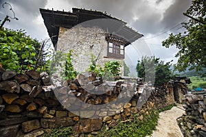 Traditional Bhutanese farmhouse , with firewood on the fence wall , Ura Valley , Bhutan