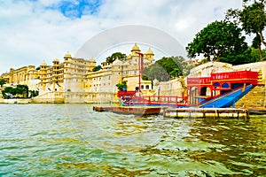 Traditional boat in front of Udaipur City Palace complex