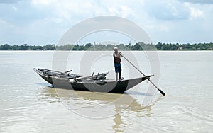 Traditional boatman ferry people Majhi rowing boat called Nauka on river Ganges Ganga. Rural Indian travel tourism and water