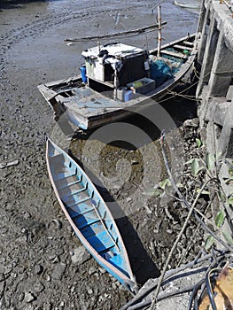 Traditional boats beached in the tidal rivuket of Revas near Alibag