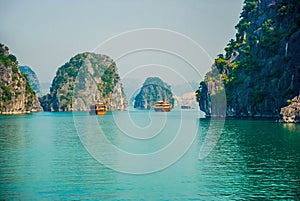 Traditional boats floating among the rock islands of Halong Bay