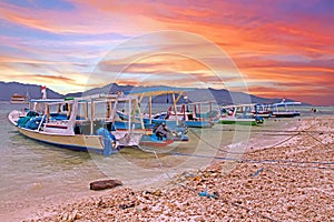 Traditional boats on Gili Meno island in Indonesia at sunset photo