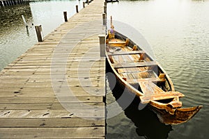 Traditional boats are leaning on a quiet dock. It`s boardwalk type dock