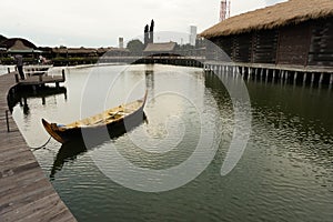 Traditional boats are leaning on a quiet dock. It`s boardwalk type dock