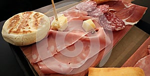 Traditional bolognese tray with typical products: tigelle, crescentine gnocco fritto, mortadella, salami and ham, Parmigiano Reg photo